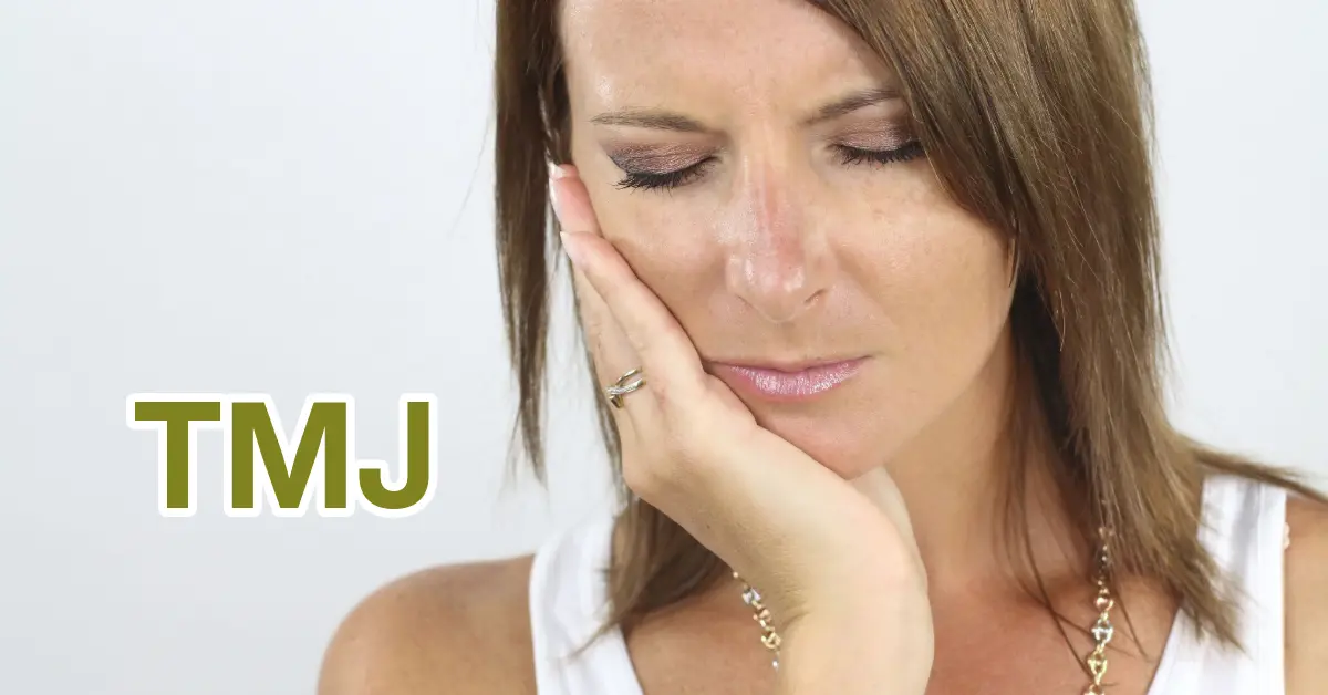 Woman with her eyes closed holding her jaw in pain, beside the word TMJ